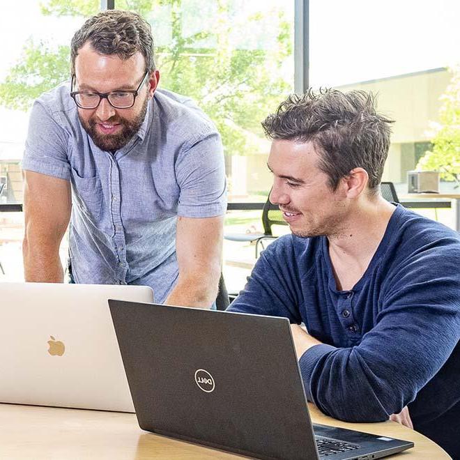 Two men meeting and looking at computers